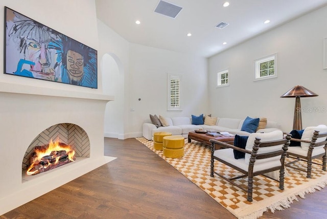 6186 Louise Cove Dr, Windermere, FL 34786 - living area with a lit fireplace, wood finished floors, recessed lighting, and arched walkways