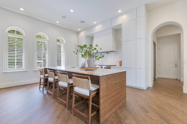 6186 Louise Cove Dr, Windermere, FL 34786 - kitchen with wood finished floors, a center island with sink, plenty of natural light, and recessed lighting