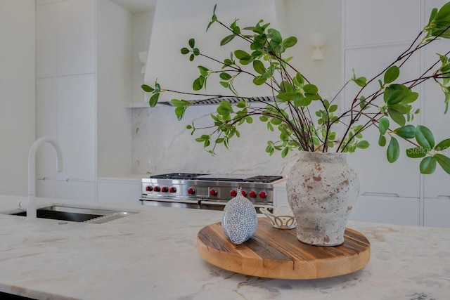 6186 Louise Cove Dr, Windermere, FL 34786 - kitchen view of light stone counters, backsplash, and white cabinetry