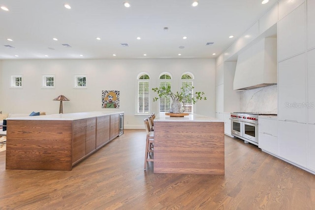 6186 Louise Cove Dr, Windermere, FL 34786 - kitchen with modern cabinets, double oven range, a center island, custom range hood, and wood finished floors