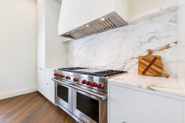 6186 Louise Cove Dr, Windermere, FL 34786 - kitchen with range with two ovens, custom exhaust hood, dark wood-style flooring, white cabinetry, and decorative backsplash