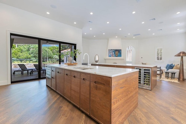6186 Louise Cove Dr, Windermere, FL 34786 - kitchen with a large island, beverage cooler, light wood-style floors, healthy amount of natural light, and recessed lighting