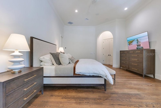 6186 Louise Cove Dr, Windermere, FL 34786 - bedroom featuring ornamental molding, arched walkways, recessed lighting, and wood finished floors