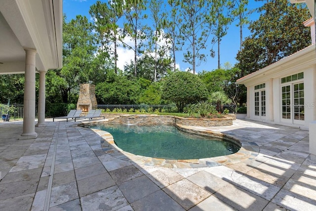 6186 Louise Cove Dr, Windermere, FL 34786 - view of swimming pool with an outdoor stone fireplace, a patio area, and french doors
