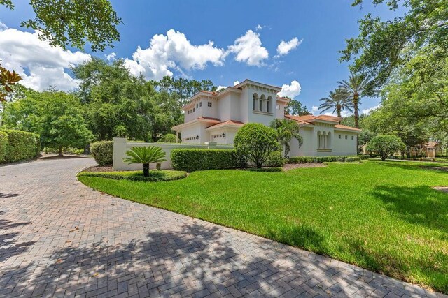 6186 Louise Cove Dr, Windermere, FL 34786 - view of side of property featuring stucco siding, a yard, and decorative driveway