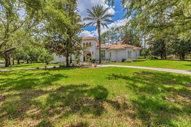 6186 Louise Cove Dr, Windermere, FL 34786 - mediterranean / spanish home featuring stucco siding, a front lawn, concrete driveway, and a chimney