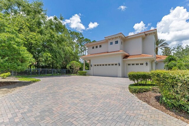 6186 Louise Cove Dr, Windermere, FL 34786 - view of front of house with a tile roof, decorative driveway, a garage, and stucco siding