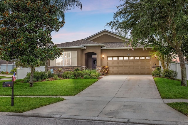 5723 Tarleton Way, Mount Dora, FL 32757 - view of front of house featuring stucco siding, a garage, driveway, stone siding, and roof with shingles