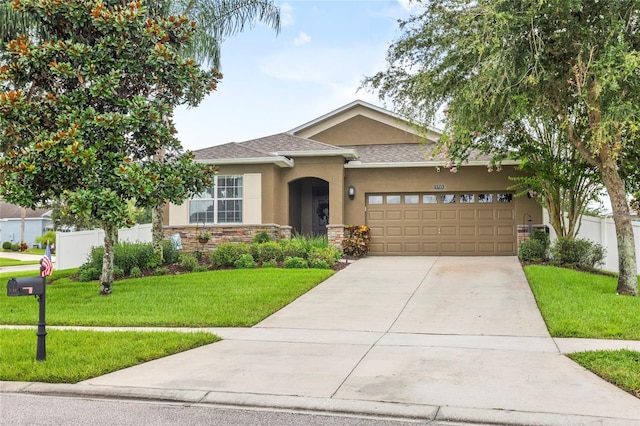 5723 Tarleton Way, Mount Dora, FL 32757 - view of front facade with stucco siding, a garage, driveway, stone siding, and roof with shingles