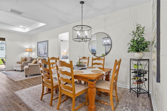 5723 Tarleton Way, Mount Dora, FL 32757 - dining space with wood finished floors, a chandelier, a raised ceiling, and recessed lighting