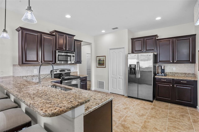 5723 Tarleton Way, Mount Dora, FL 32757 - kitchen featuring appliances with stainless steel finishes, dark brown cabinetry, decorative backsplash, and recessed lighting
