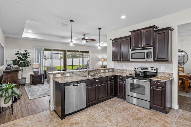 5723 Tarleton Way, Mount Dora, FL 32757 - kitchen with stainless steel appliances, a peninsula, ceiling fan, dark brown cabinetry, and recessed lighting