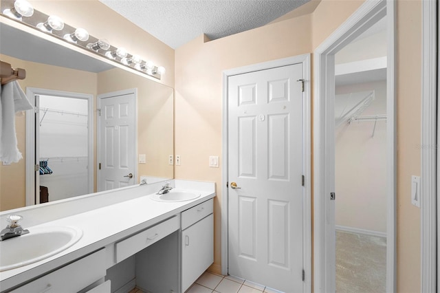 3707 Doune Way, Clermont, FL 34711 - full bath featuring double vanity, a spacious closet, a textured ceiling, and tile patterned flooring