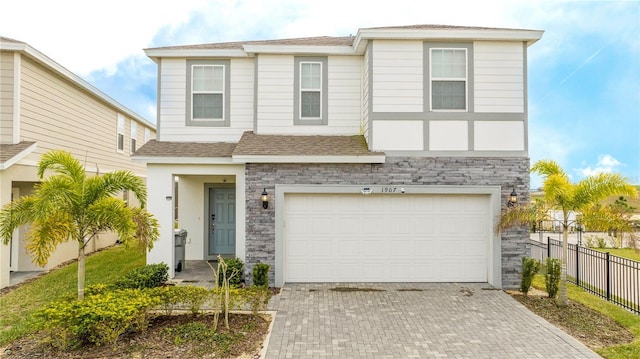 1907 Summer Dr, Davenport, FL 33897 - view of front facade with stone siding, decorative driveway, a garage, and roof with shingles