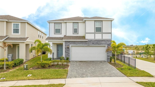 1907 Summer Dr, Davenport, FL 33897 - view of front facade with driveway, stone siding, a garage, and roof with shingles