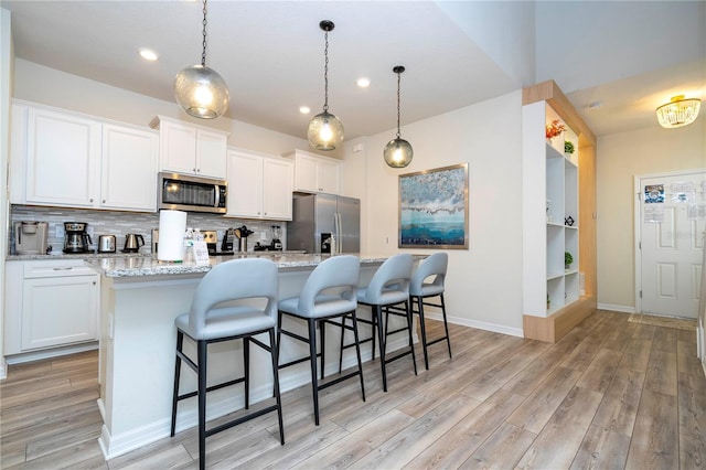 1907 Summer Dr, Davenport, FL 33897 - kitchen featuring appliances with stainless steel finishes, light wood-style floors, white cabinets, backsplash, and recessed lighting