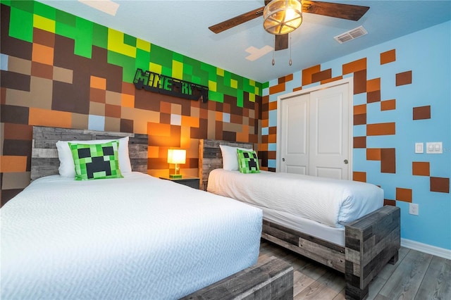 1907 Summer Dr, Davenport, FL 33897 - bedroom featuring an accent wall, wallpapered walls, wood finished floors, a closet, and ceiling fan