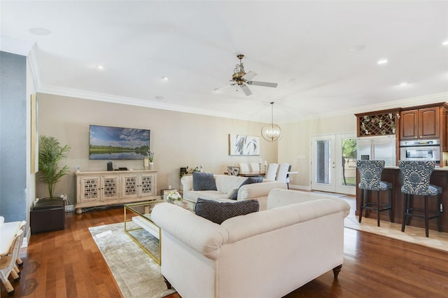 8445 Shady Glen Dr, Orlando, FL 32819 - living room featuring ceiling fan, dark wood-style floors, ornamental molding, a chandelier, and recessed lighting