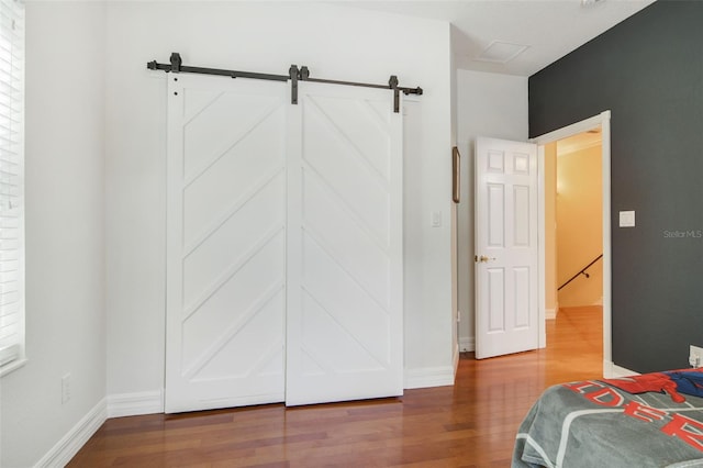 8445 Shady Glen Dr, Orlando, FL 32819 - unfurnished bedroom with wood finished floors and a barn door