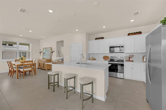 3702 Haddon Ave, Davenport, FL 33837 - kitchen featuring stainless steel appliances, a kitchen breakfast bar, light tile patterned flooring, decorative backsplash, and a center island with sink
