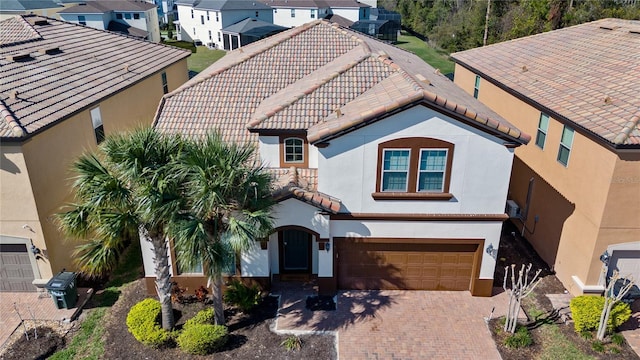 1626 Lima Ave, Kissimmee, FL 34747 - view of front of house featuring an attached garage, stucco siding, decorative driveway, a tile roof, and a residential view