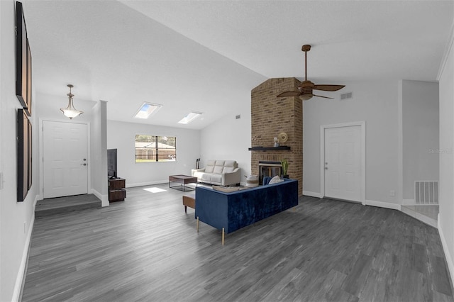 2025 Mango Tree Dr, Edgewater, FL 32141 - living area featuring vaulted ceiling, a ceiling fan, wood finished floors, a brick fireplace, and a skylight