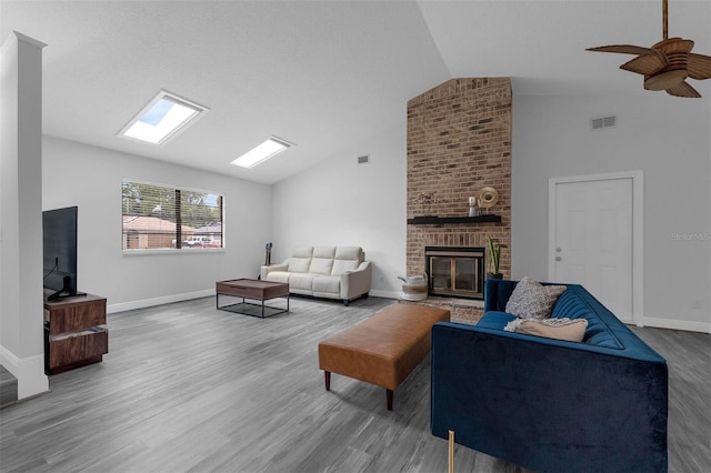 2025 Mango Tree Dr, Edgewater, FL 32141 - living area featuring lofted ceiling, wood finished floors, a brick fireplace, and a ceiling fan
