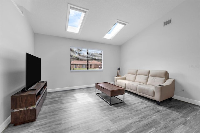 2025 Mango Tree Dr, Edgewater, FL 32141 - living area featuring wood finished floors, vaulted ceiling, and a skylight