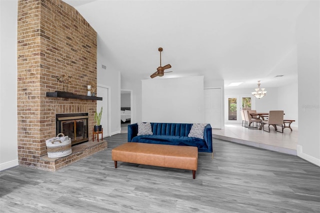 2025 Mango Tree Dr, Edgewater, FL 32141 - living area featuring wood finished floors, a chandelier, vaulted ceiling, and a brick fireplace