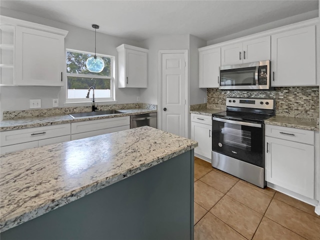 1301 Brenway Dr, Mascotte, FL 34753 - kitchen with stainless steel appliances, white cabinetry, decorative backsplash, light tile patterned floors, and hanging light fixtures