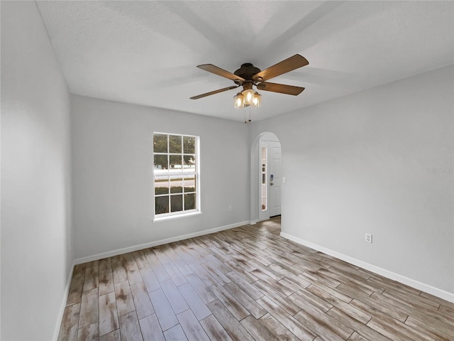 1301 Brenway Dr, Mascotte, FL 34753 - unfurnished room featuring arched walkways, wood finished floors, and a ceiling fan