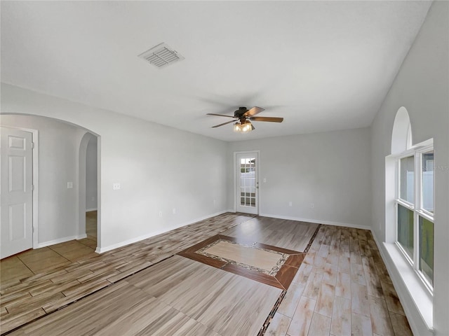 1301 Brenway Dr, Mascotte, FL 34753 - spare room with ceiling fan, arched walkways, and wood finished floors