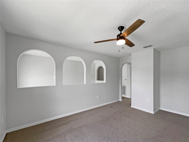 1301 Brenway Dr, Mascotte, FL 34753 - unfurnished room with a ceiling fan, carpet flooring, a textured ceiling, and arched walkways