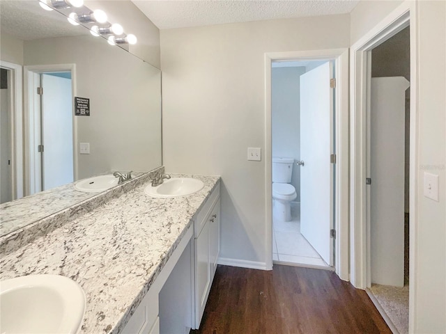 6460 Preakness Dr, Orlando, FL 32818 - full bathroom with double vanity, wood finished floors, and a textured ceiling