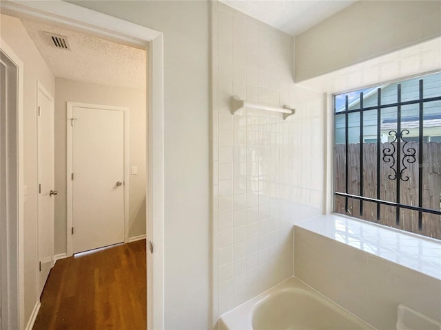 6460 Preakness Dr, Orlando, FL 32818 - full bathroom featuring a garden tub, wood finished floors, and a textured ceiling