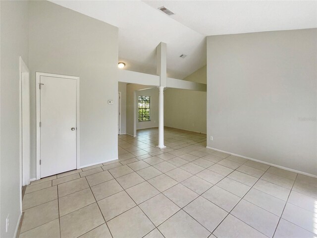 6460 Preakness Dr, Orlando, FL 32818 - empty room featuring light tile patterned flooring, vaulted ceiling, and decorative columns