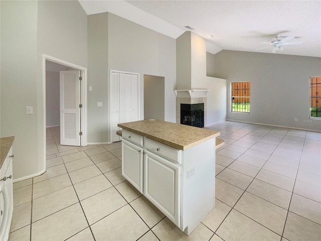 6460 Preakness Dr, Orlando, FL 32818 - kitchen featuring high vaulted ceiling, light tile patterned flooring, a center island, a ceiling fan, and a fireplace