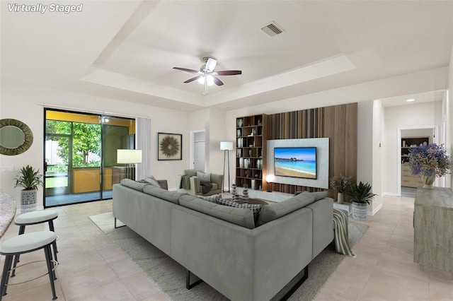 2236 Landside Dr, Valrico, FL 33594 - living room with a tray ceiling, ceiling fan, light tile patterned floors, and a fireplace