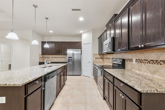 2236 Landside Dr, Valrico, FL 33594 - kitchen featuring appliances with stainless steel finishes, backsplash, dark brown cabinetry, light tile patterned floors, and hanging light fixtures