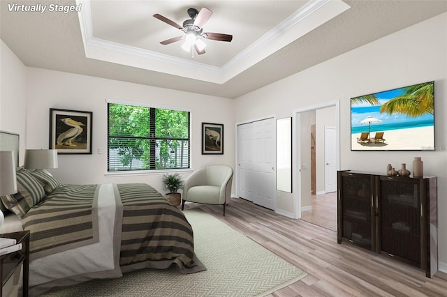 2236 Landside Dr, Valrico, FL 33594 - bedroom with a raised ceiling, light wood-style flooring, crown molding, and ceiling fan