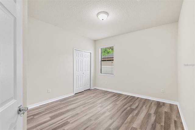 2236 Landside Dr, Valrico, FL 33594 - empty room with light wood-style flooring and a textured ceiling