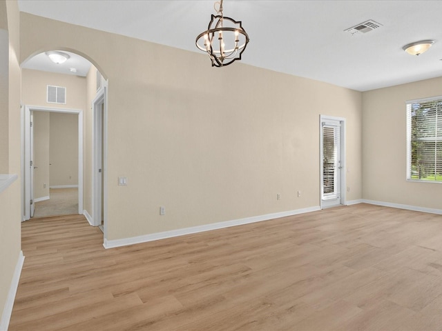 1353 Venezia Ct Unit 205, Davenport, FL 33896 - spare room with arched walkways, light wood finished floors, and a chandelier