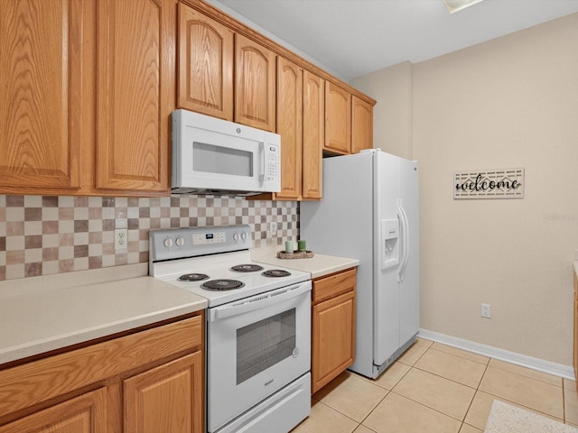 1353 Venezia Ct Unit 205, Davenport, FL 33896 - kitchen with white appliances, decorative backsplash, light tile patterned floors, light countertops, and brown cabinets