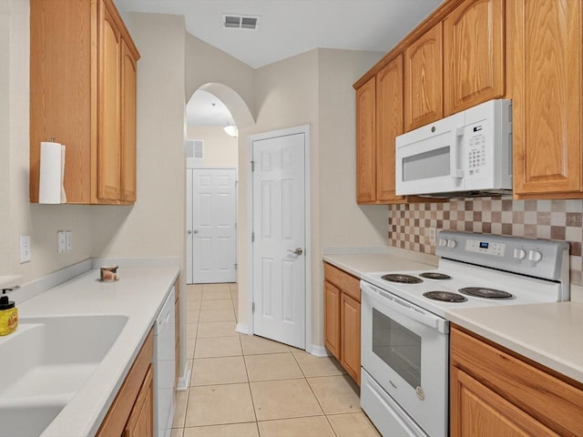 1353 Venezia Ct Unit 205, Davenport, FL 33896 - kitchen featuring white appliances, light tile patterned flooring, tasteful backsplash, arched walkways, and light countertops