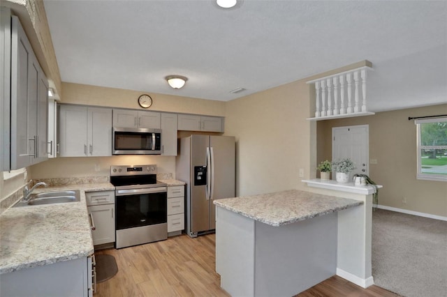 749 Ridge Blvd, South Daytona, FL 32119 - kitchen with stainless steel appliances, gray cabinetry, light wood finished floors, and light stone countertops