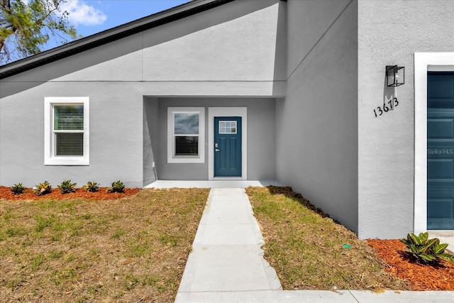 13673 SW 43th Cir, Ocala, FL 34473 - entrance to property featuring stucco siding and a lawn