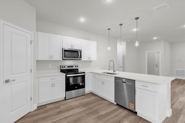 13673 SW 43th Cir, Ocala, FL 34473 - kitchen with appliances with stainless steel finishes, a peninsula, white cabinets, and recessed lighting