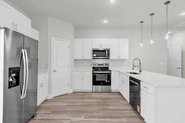 13673 SW 43th Cir, Ocala, FL 34473 - kitchen with stainless steel appliances, a peninsula, light wood-style floors, white cabinetry, and light countertops