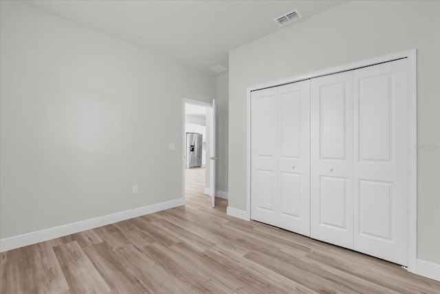 13673 SW 43th Cir, Ocala, FL 34473 - unfurnished bedroom with light wood-style floors, stainless steel fridge, and a closet