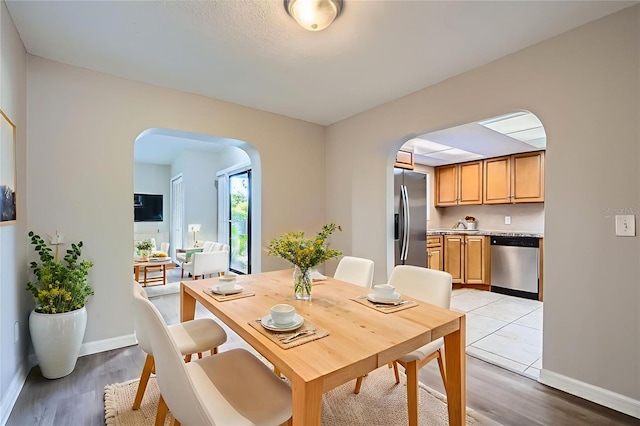 1175 Tracy Dr, Port Orange, FL 32129 - dining room with arched walkways and light wood-type flooring
